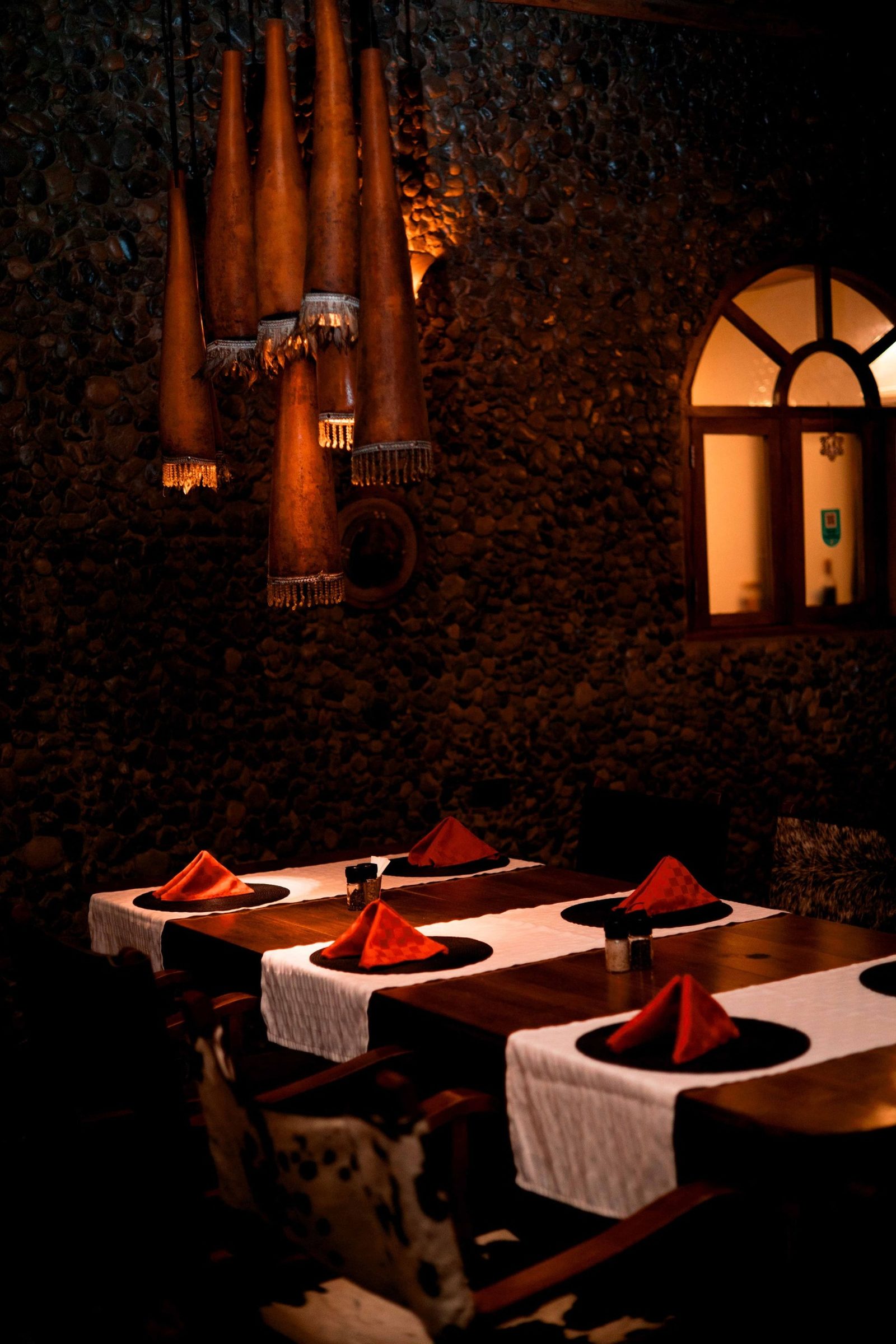 Candlelit dining table with gourd pendant lamps at Mtoni River Lodge