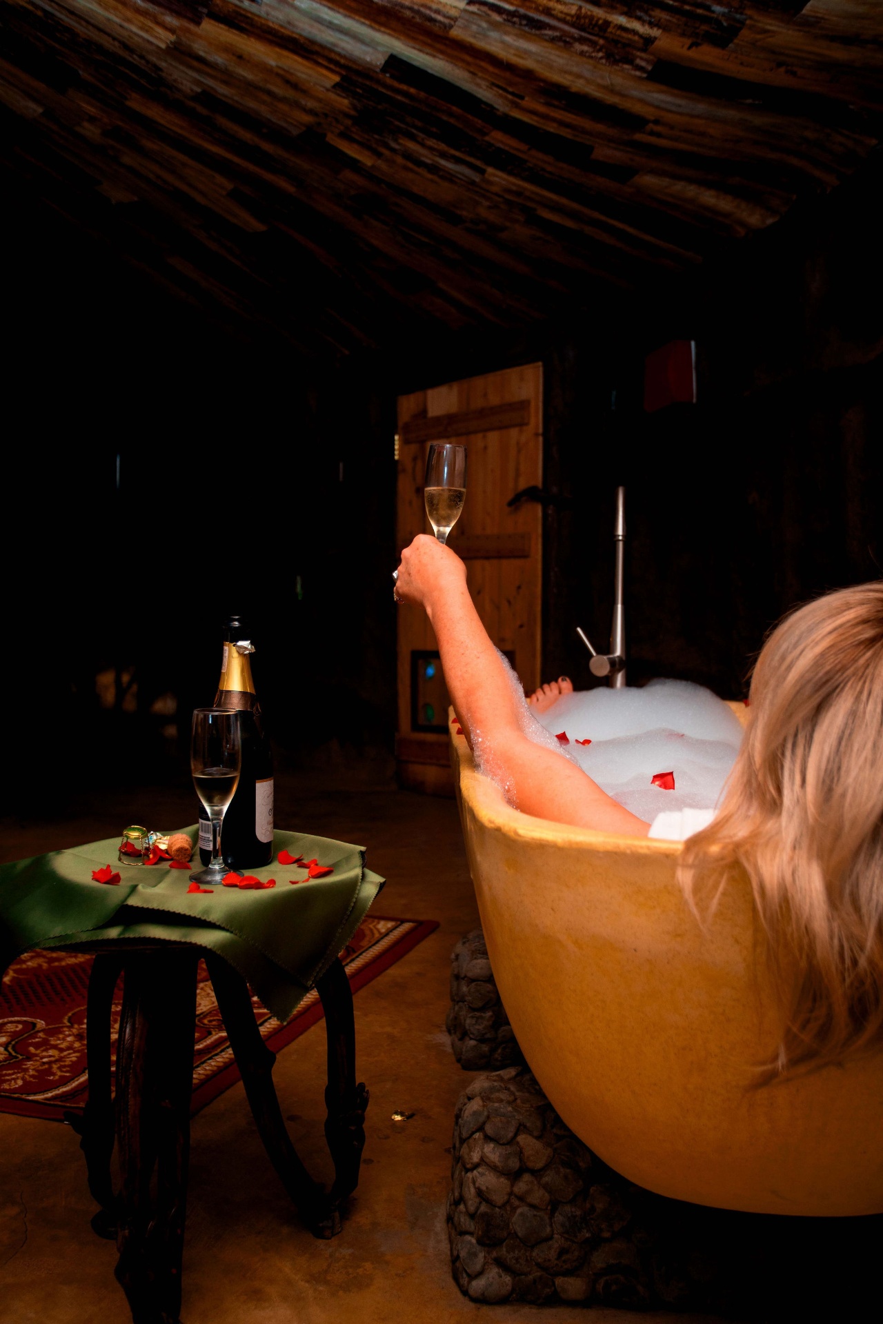 Candlelit bubble bath with champagne beneath the thatched roof of a Mtoni River Lodge suite